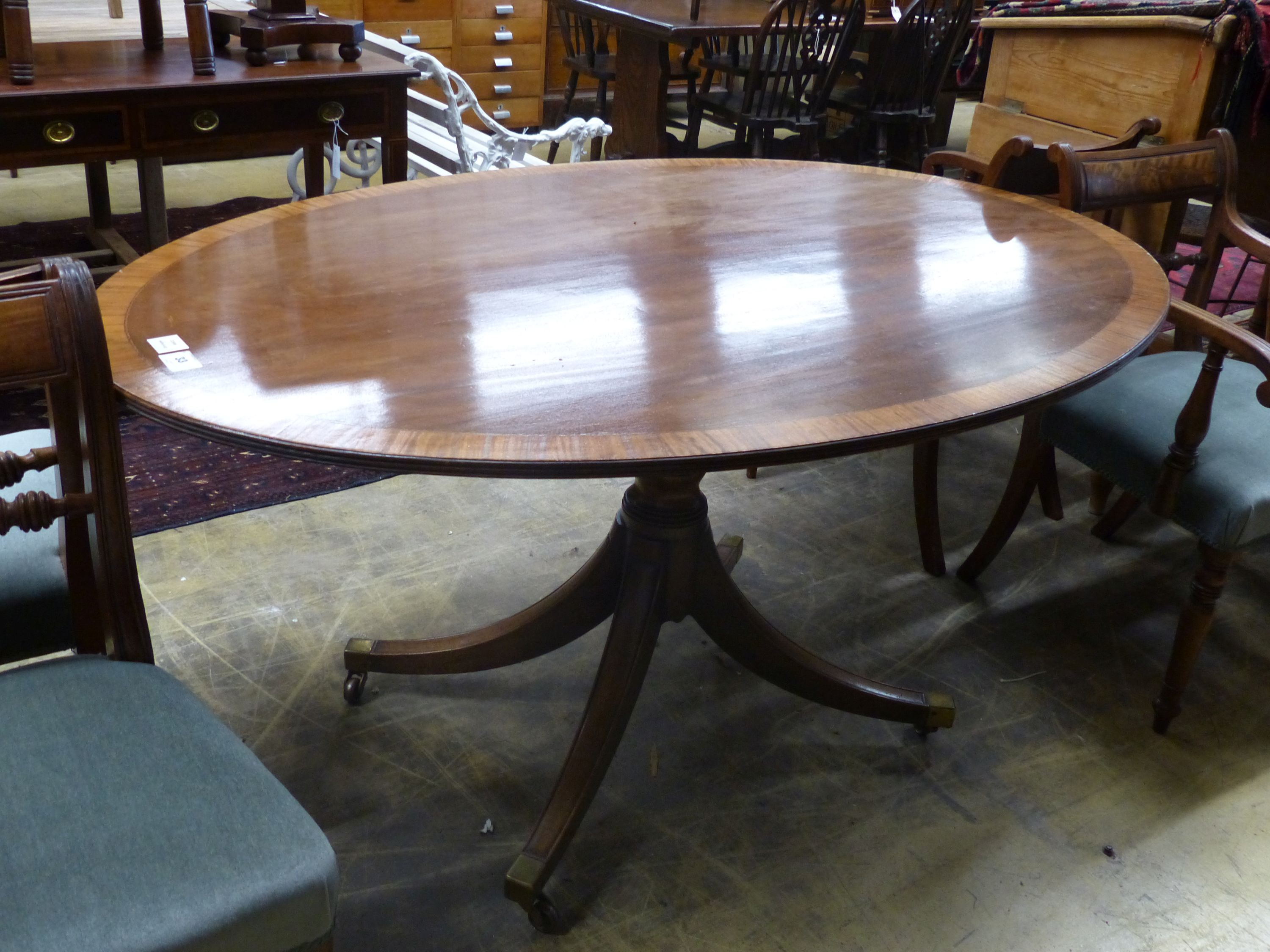 A Regency style oval banded mahogany dining table, length 150cm, depth 103cm, height 76cm